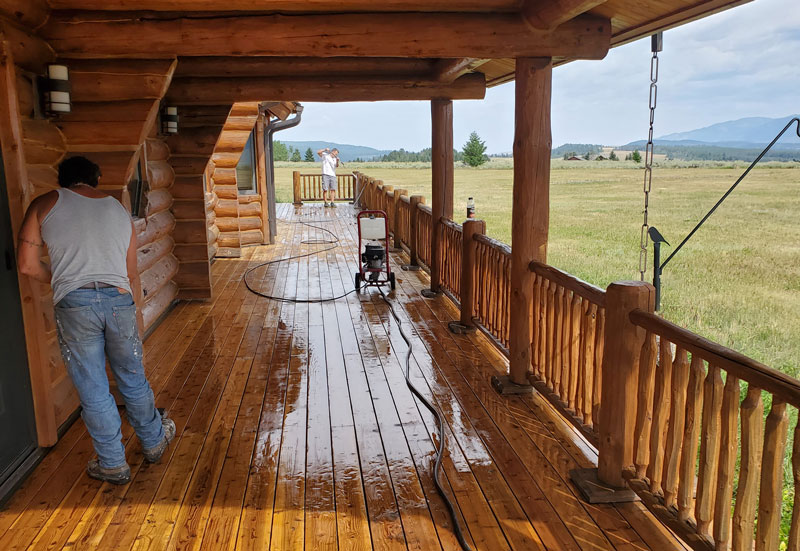 Cabin-Power-Washing 2 workers from Gallatin Painters pressure washing a cabins porch and railings
